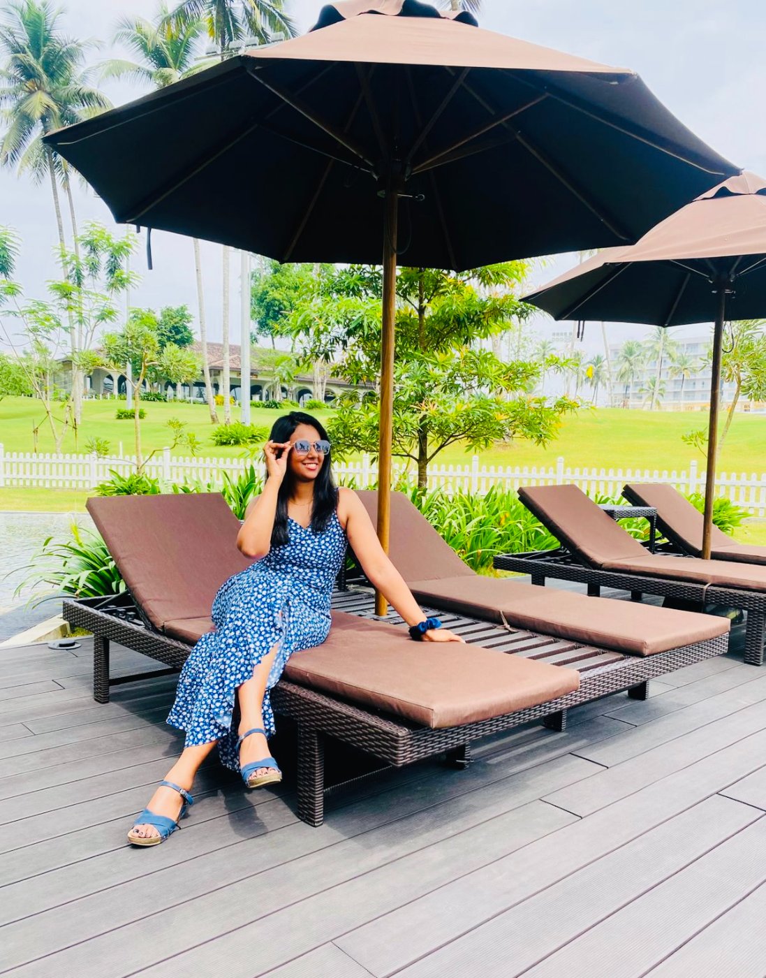 Shivanthi relaxing by the pool under a big umbrella